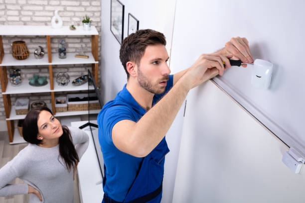 técnico montando una alarma en una tienda